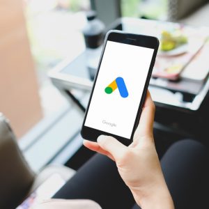Mujer joven revisando anuncios de Google Ads en su smartphone